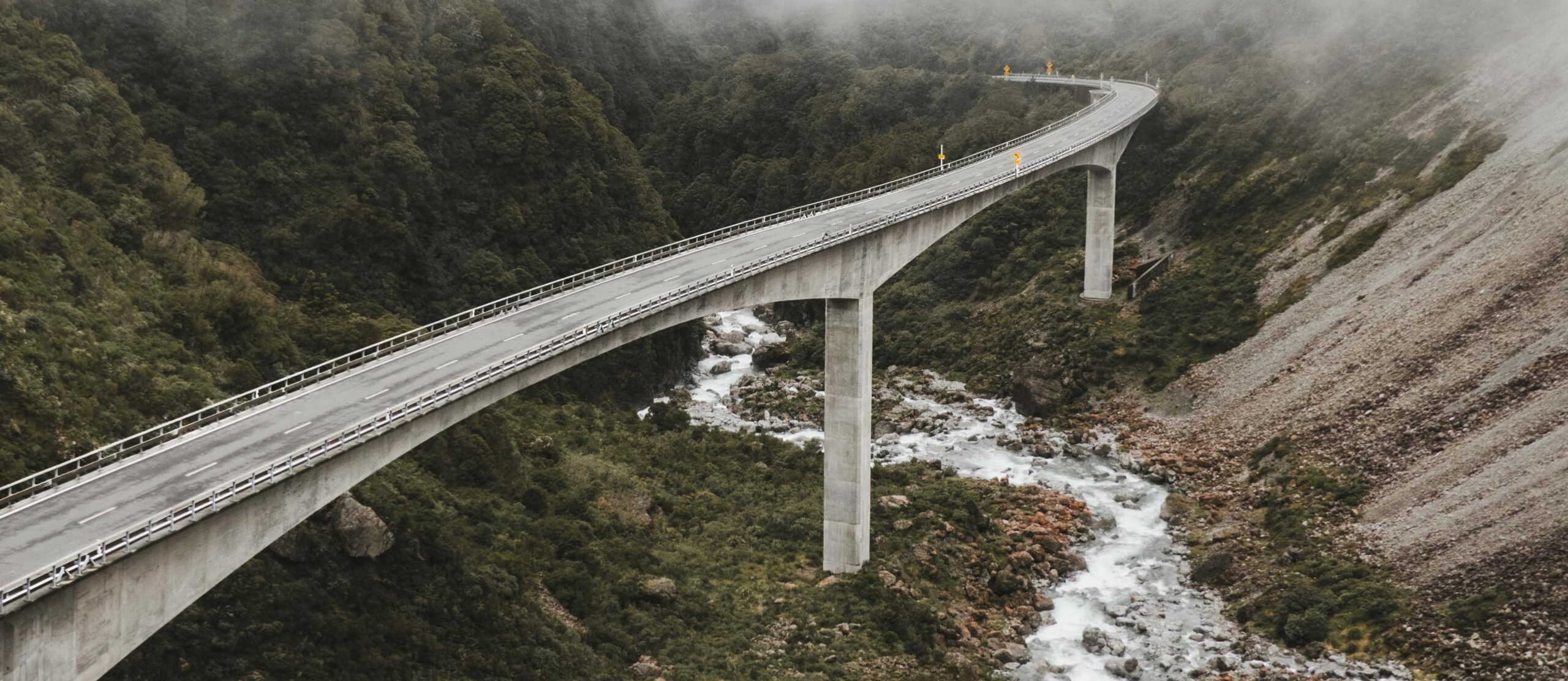 A bridge over a raging river is a metaphor for overcoming hurdles during a brand refresh.